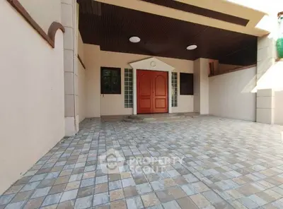Spacious entrance with tiled flooring and elegant wooden door in a modern home.