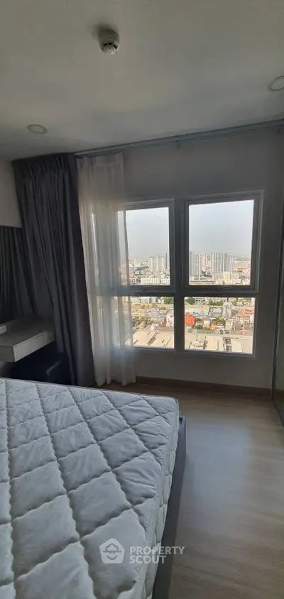 Modern bedroom with large window offering stunning city view