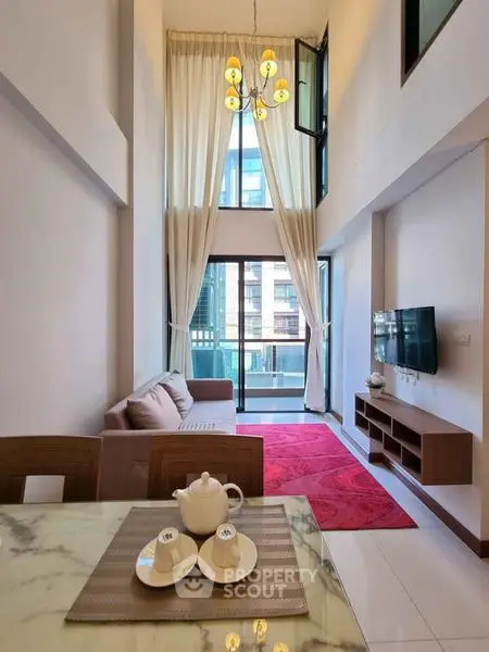 Luxurious high-ceiling living room with modern decor and balcony view