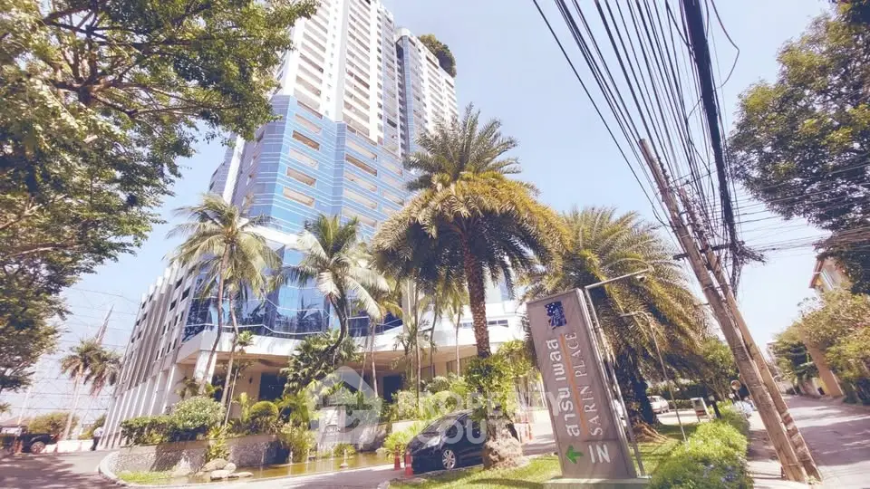 Stunning high-rise building with lush landscaping and palm trees, offering a luxurious urban living experience.