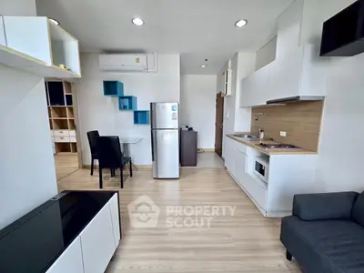 Modern open-layout kitchen and living area with sleek design and ample natural light.