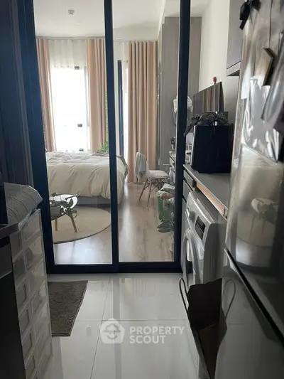 Modern apartment interior with bedroom and kitchen featuring sleek design and natural light.