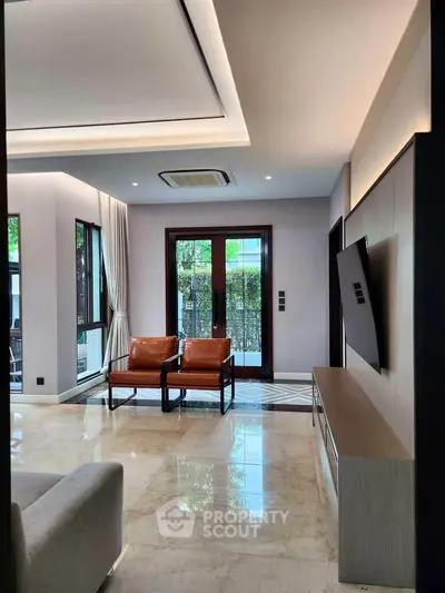 Luxurious modern living room with elegant marble flooring and stylish leather chairs, perfect for relaxation.