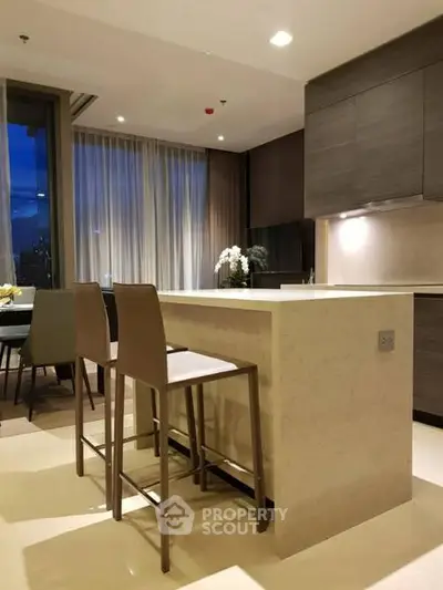 Modern kitchen with sleek design and open layout, featuring a stylish breakfast bar and elegant lighting.