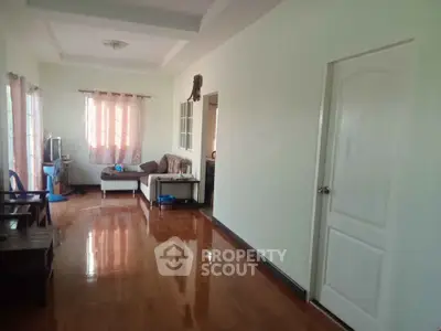 Spacious living room with polished wooden floors and cozy seating area.