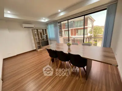 Spacious modern dining area with large windows and wooden flooring, perfect for entertaining.