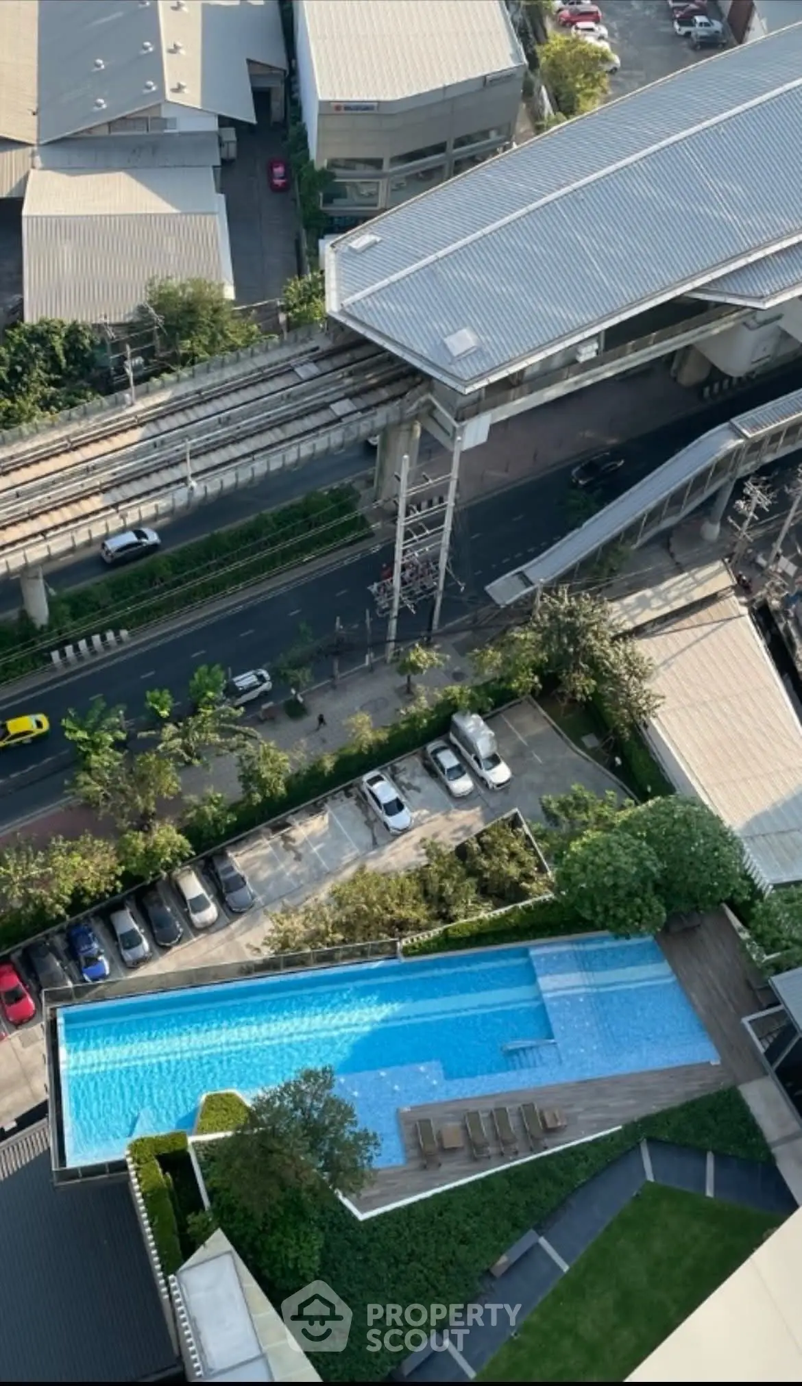 Stunning aerial view of modern residential complex with pool and parking, ideal urban living.