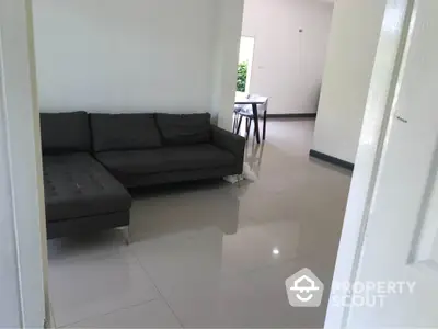 Spacious living room with modern gray sofa and polished tile flooring