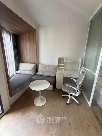 Modern study room with cozy seating and sleek desk in a bright apartment.