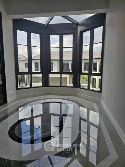 Stunning modern living room with large windows and glossy marble floor, offering a bright and elegant space.