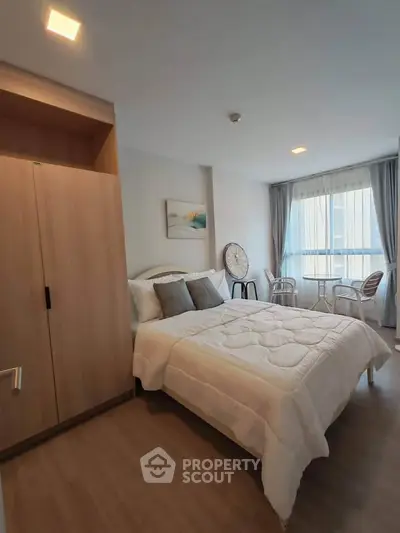 Cozy bedroom with modern decor and large window for natural light