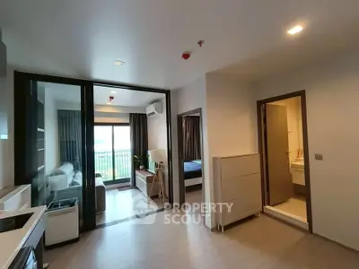 Modern apartment interior with open layout, featuring a cozy living room, kitchen, and bedroom with balcony access.
