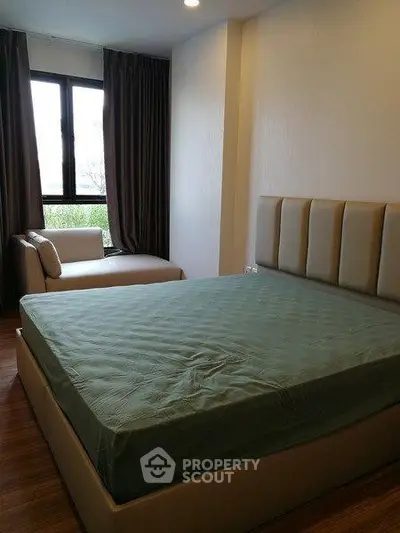 Cozy bedroom with large window and stylish bed in modern apartment