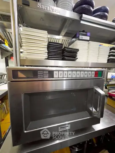 Modern kitchen with stainless steel microwave and organized shelving