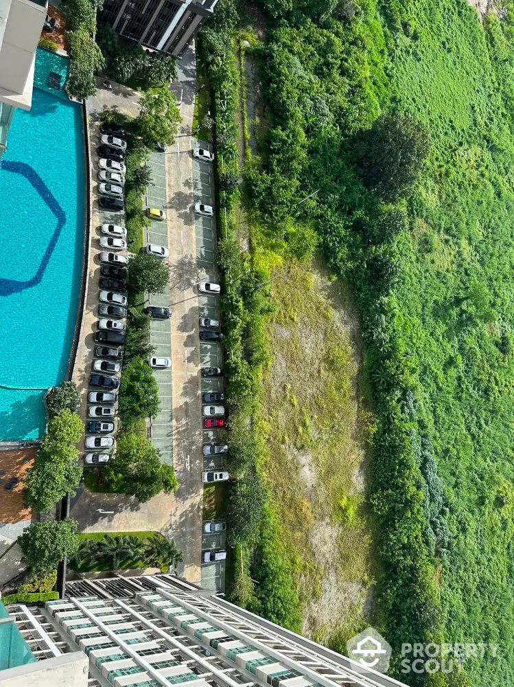 Stunning aerial view of modern apartment building with pool and lush greenery