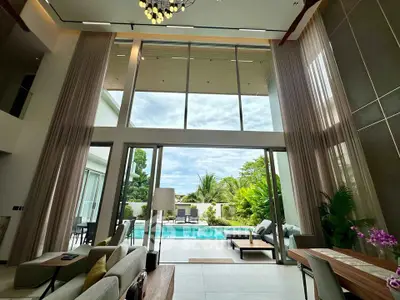 Luxurious living room with high ceilings and pool view, perfect for modern living.
