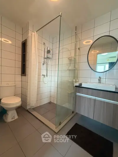 Modern bathroom with glass shower and stylish vanity in contemporary home.