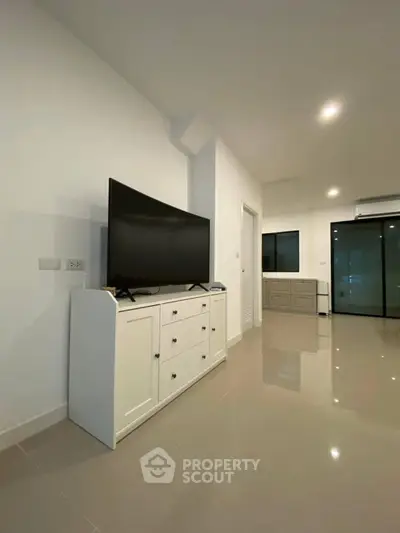 Modern living room with sleek TV stand and glossy tiled flooring