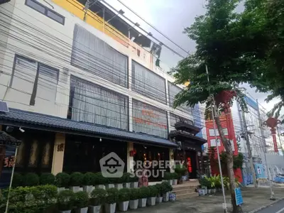 Charming commercial building with modern facade and lush greenery in urban setting.