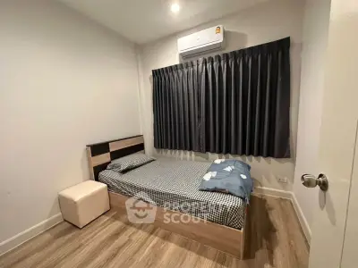 Cozy bedroom with single bed, modern decor, and air conditioning.