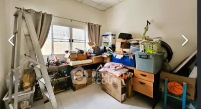 Cluttered storage room with boxes and miscellaneous items, ideal for organizing potential.