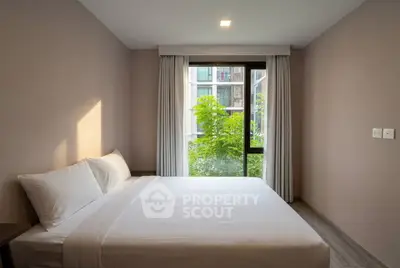 Cozy bedroom with large window and garden view in modern apartment