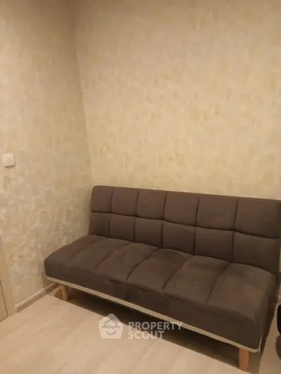 Cozy small living room with a modern brown sofa and textured walls, perfect for compact spaces.