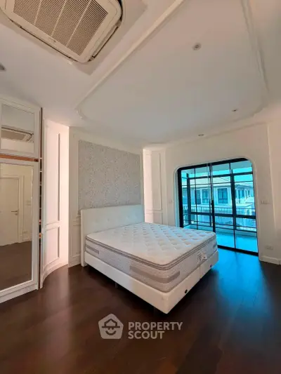 Spacious bedroom with elegant design and large windows offering natural light and a view.