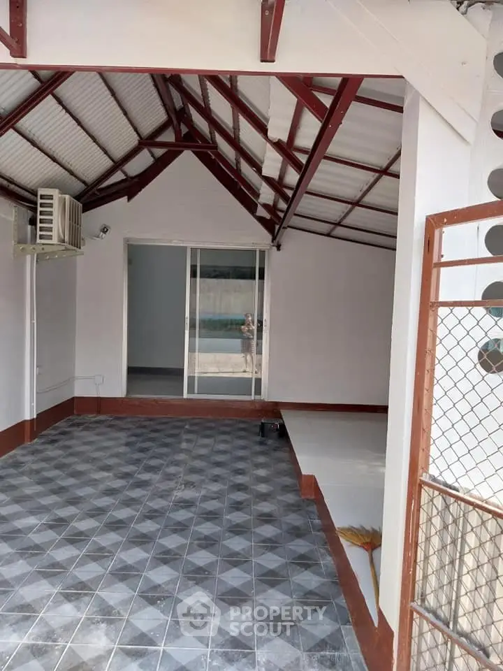 Spacious covered patio with tiled flooring and air conditioning, perfect for outdoor relaxation.