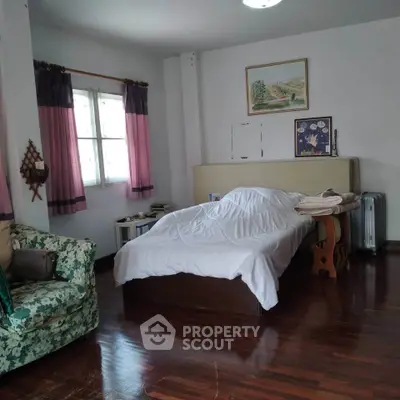 Spacious bedroom with wooden floors and cozy decor