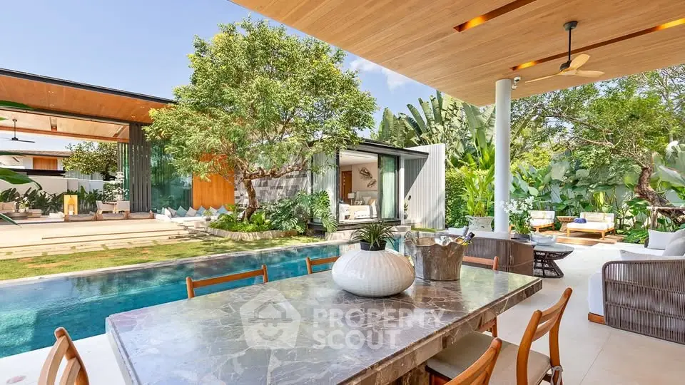 Luxurious outdoor patio with pool and lush garden, perfect for entertaining.