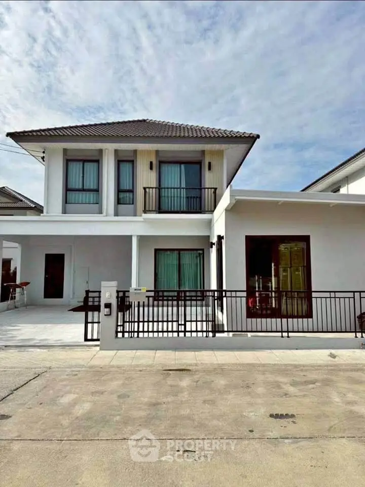 Modern two-story house with sleek design and spacious driveway.
