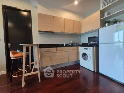 Modern kitchen with wooden cabinets, washing machine, and breakfast bar in stylish apartment.