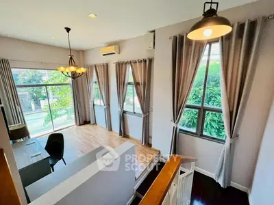 Spacious living room with large windows and elegant lighting, offering a bright and inviting atmosphere.