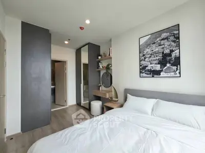 Modern bedroom with sleek design, featuring a large bed, stylish decor, and ample natural light.