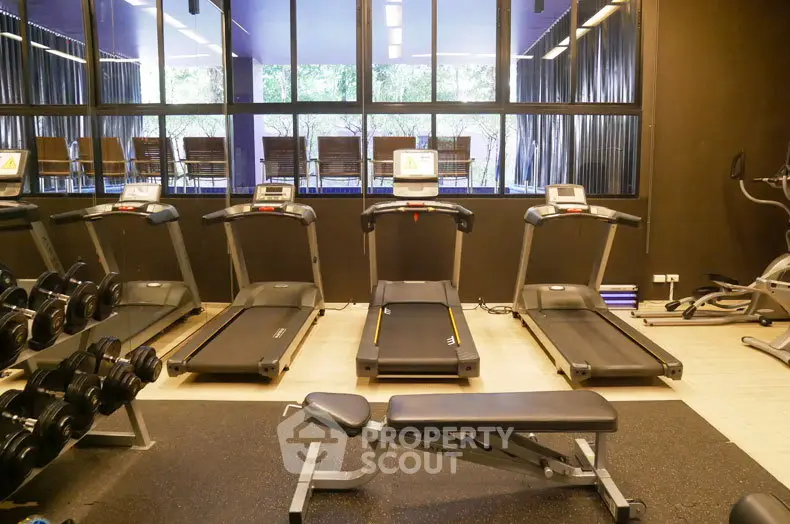 Modern gym with treadmills and weights in a luxury apartment building