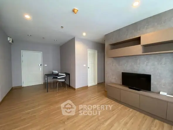 Spacious modern living room with wooden flooring and built-in TV unit.