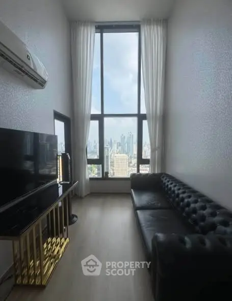 Luxurious high-ceiling living room with stunning city view and elegant black leather sofa.