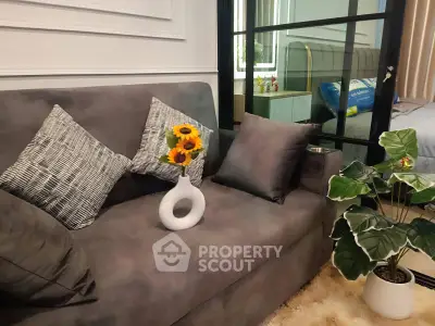Stylish living room with modern sofa, decorative pillows, and indoor plants for a cozy ambiance.