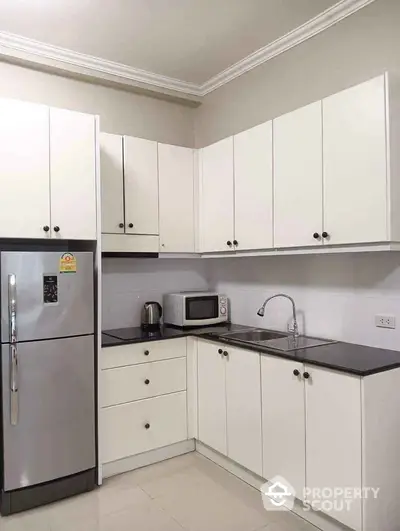 Modern kitchen with sleek white cabinets and stainless steel appliances