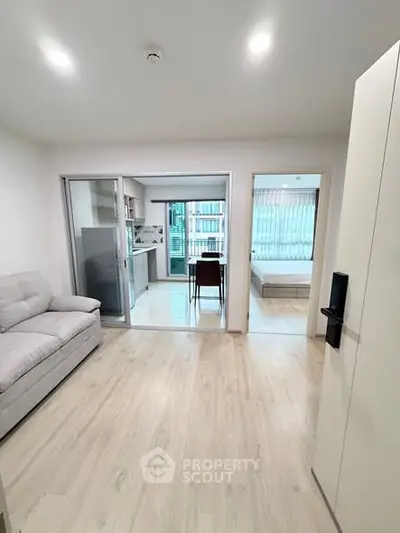 Modern open-plan apartment with sleek kitchen and cozy living area, perfect for urban living.