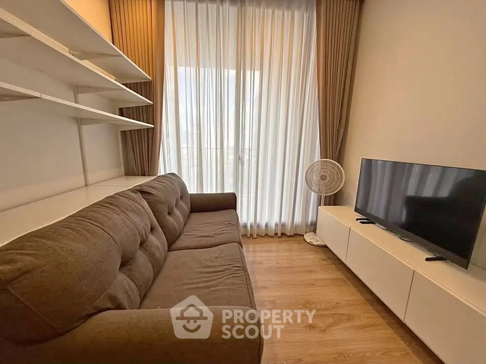 Cozy living room with modern sofa, TV, and elegant curtains in a stylish apartment.