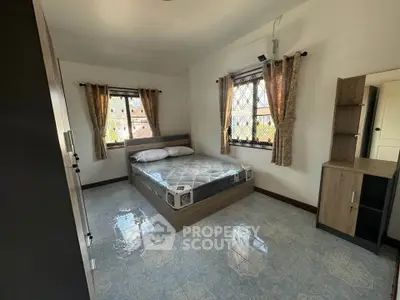 Spacious bedroom with modern furnishings and natural light, perfect for comfort and relaxation.