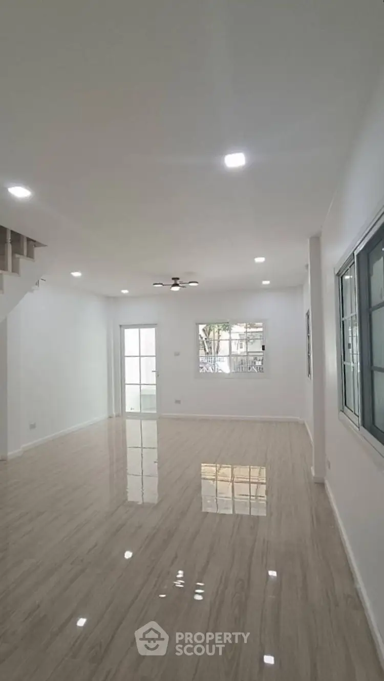 Spacious and bright living room with modern flooring and large windows.