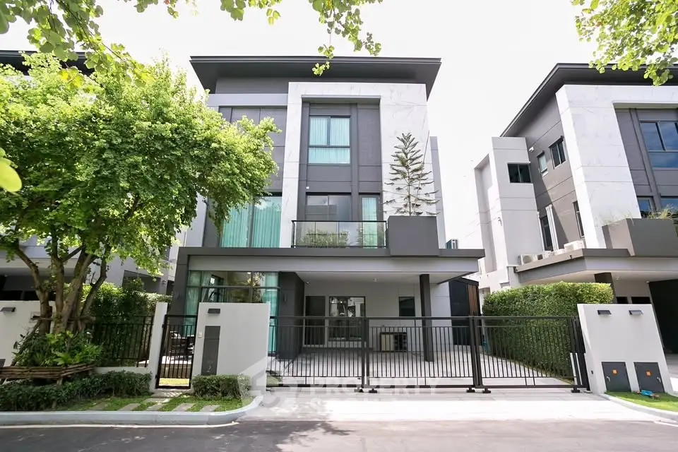 Modern three-story house with sleek design and lush greenery in a serene neighborhood.