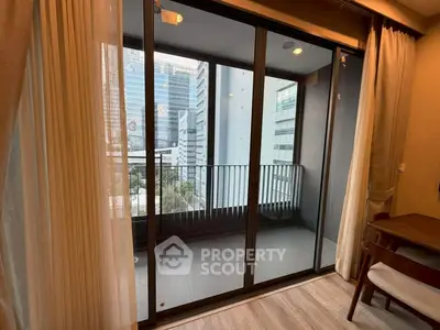 Modern apartment balcony with city view and floor-to-ceiling glass doors