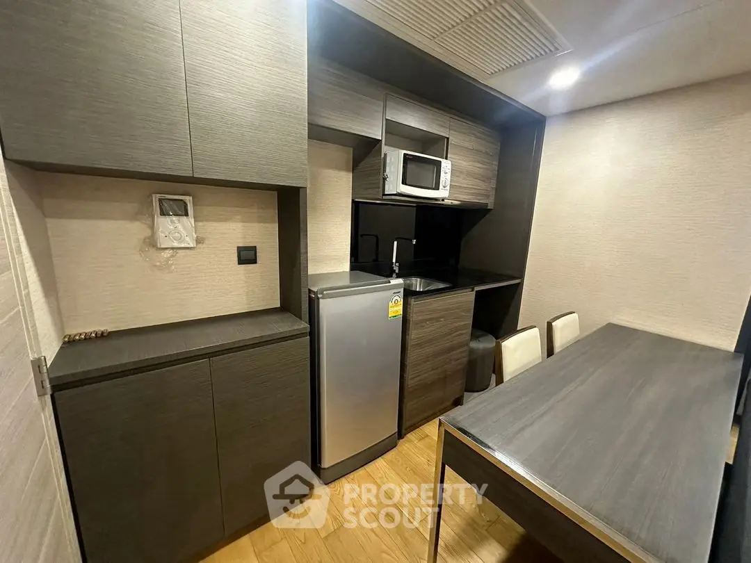 Modern compact kitchen with sleek cabinetry and dining area in urban apartment