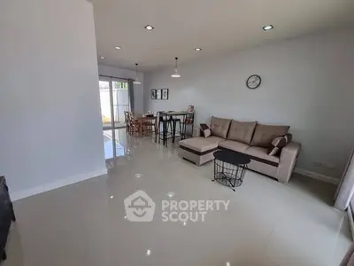 Spacious modern living room with sleek furniture and open dining area, perfect for entertaining.