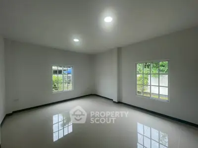 Spacious empty room with large windows and glossy tiled floor, perfect for customization.