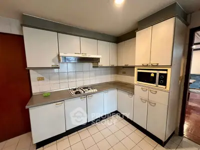 Spacious kitchen with modern cabinetry and built-in appliances, featuring a gas stove and ample counter space.